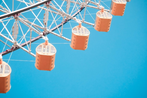 Low angle view of ferris wheel against clear blue sky