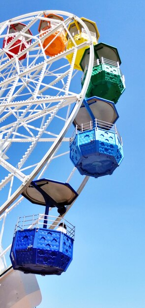 Low angle view of ferris wheel against clear blue sky