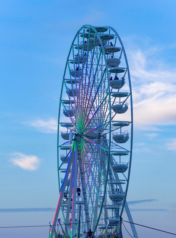 Photo low angle view of ferris wheel against sea