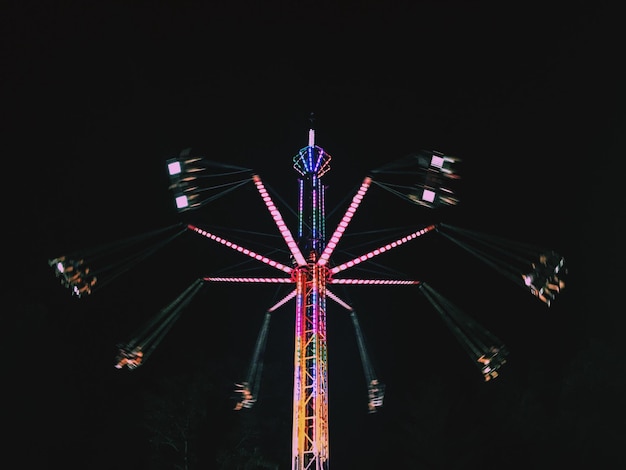 夜の空に照らされたフェリスホイールの低角度の景色