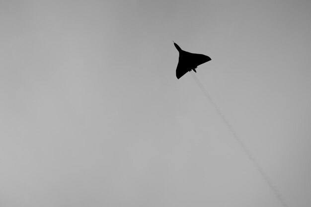 Foto vista a bassa angolazione di un aereo da combattimento che vola in un cielo limpido