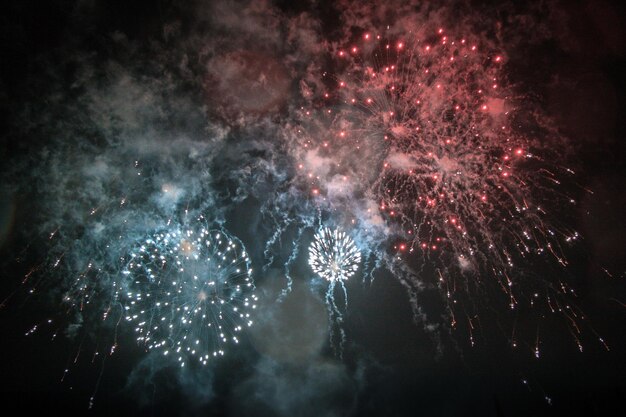 Photo low angle view of firework display against sky at night