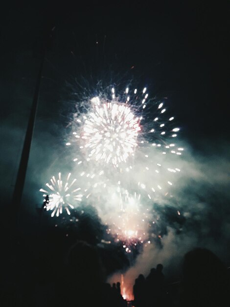 Low angle view of firework display at night