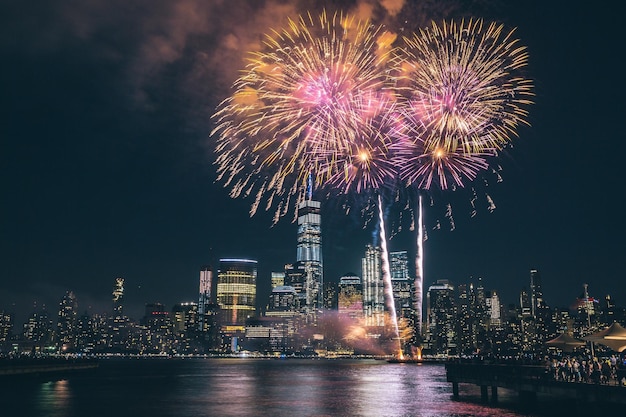 low angle view of firework display over river in city at night