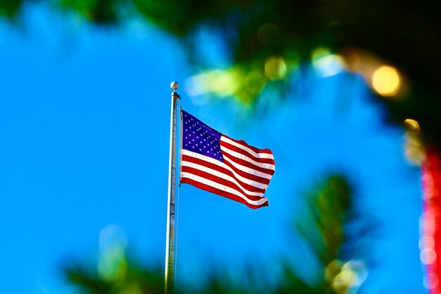 Low angle view of flag against blue sky