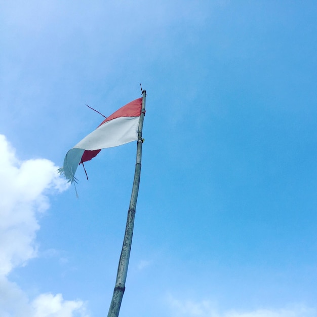 Low angle view of flag against blue sky