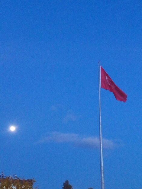 Low angle view of flag against blue sky