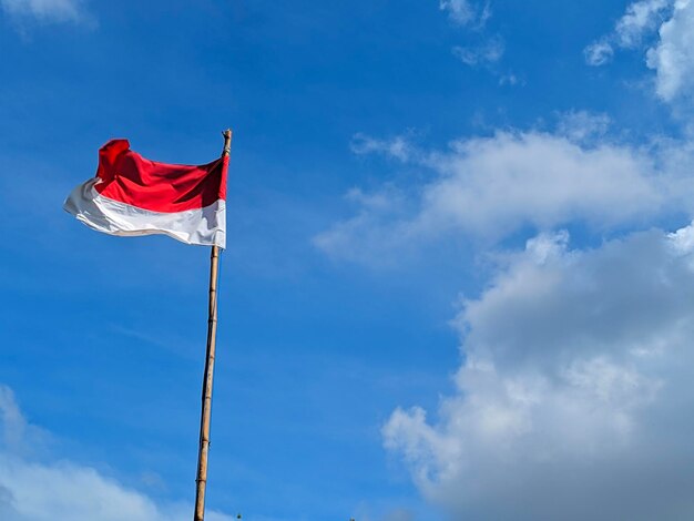 Low angle view of flag against blue sky