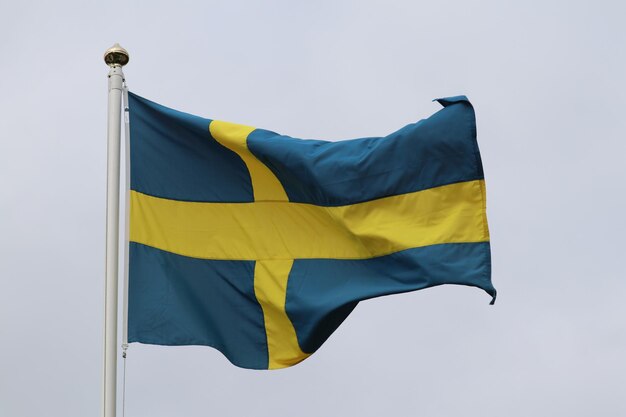 Photo low angle view of flag against blue sky