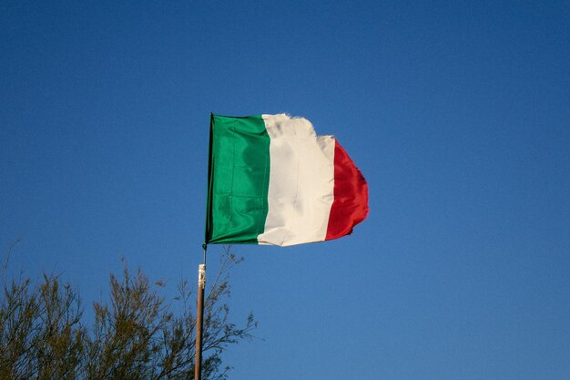 Low angle view of flag against blue sky