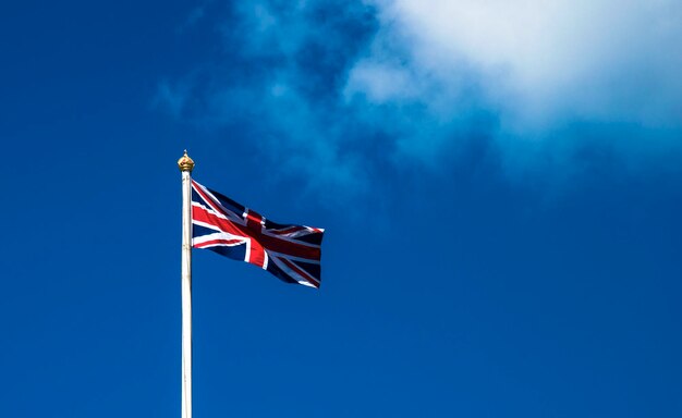 Low angle view of flag against blue sky