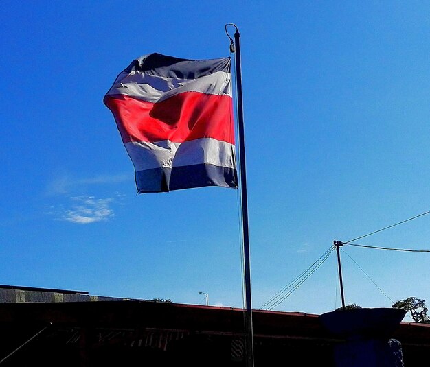 Low angle view of flag against clear blue sky