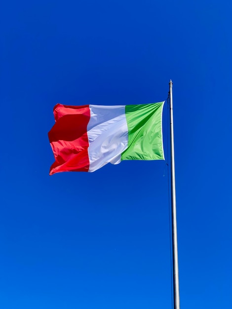 Low angle view of flag against clear blue sky