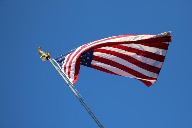 Photo low angle view of flag against clear blue sky