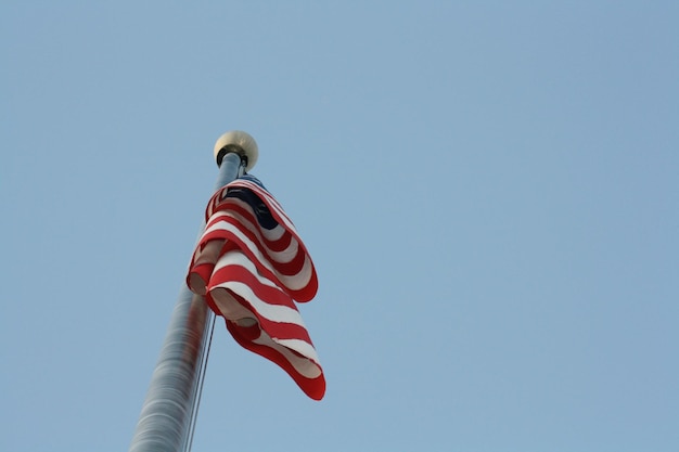 Low angle view of flag against clear blue sky