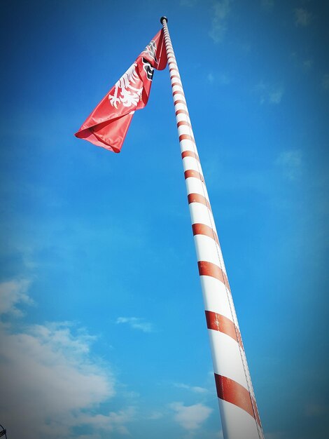 Low angle view of flags against blue sky