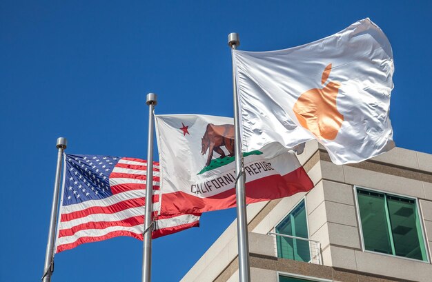 Low angle view of flags against clear blue sky