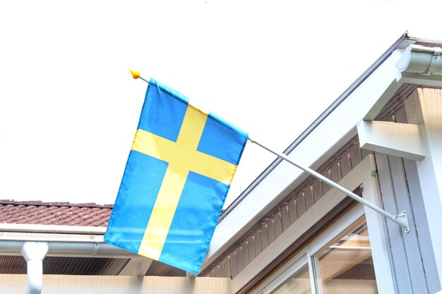 Photo low angle view of flags on building against clear sky