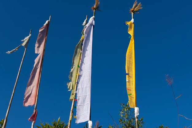 Low angle view of flags hanging against blue sky