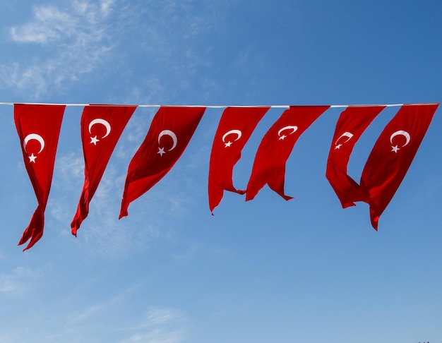 Low angle view of flags hanging against blue sky