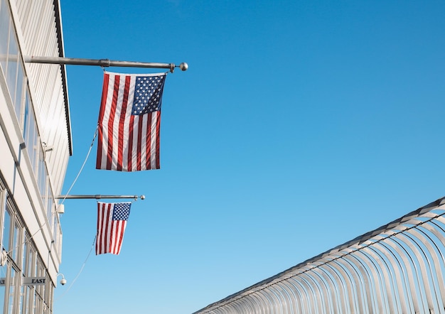 Photo low angle view of flags hanging against clear blue sky