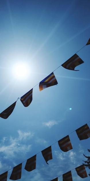 Low angle view of flags hanging against sky