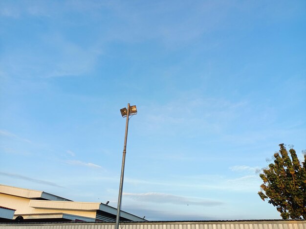 Low angle view of floodlight against blue sky