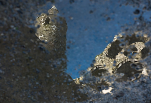 Low angle view of fort seen through wet glass against sky