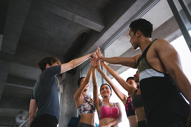 Photo low angle view of friends high-fiving in gym