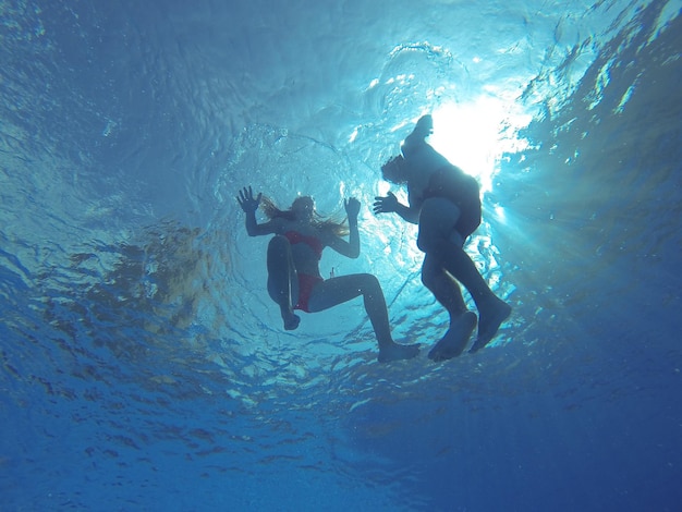 Foto vista ad angolo basso di amici che nuotano in mare