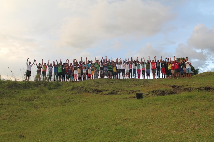 फोटो low angle view of friends with arms raised standing on hill