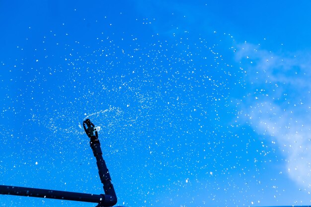 Low angle view of frozen water against blue sky on sunny day