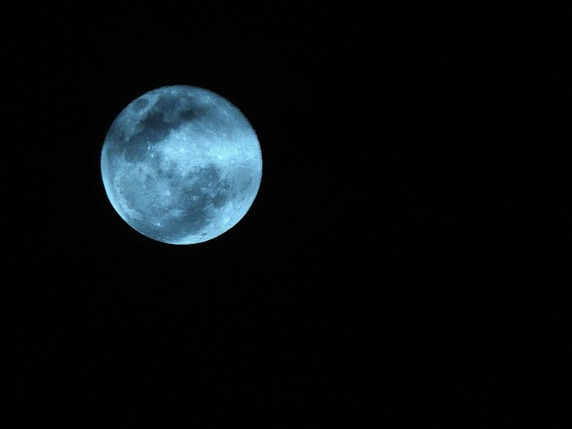 Foto vista a basso angolo della luna piena contro un cielo limpido