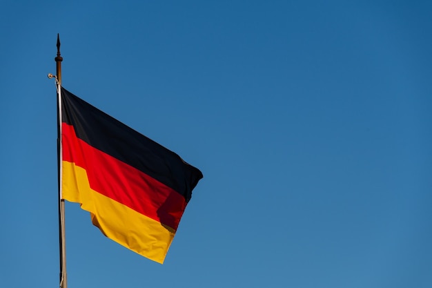 Photo low angle view of german flag against blue sky