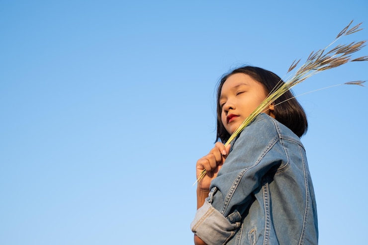Photo 澄んだ青い空の前に立っている女の子の低角度の眺め