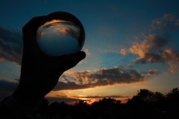 Foto riflessione a sfera di vetro a basso angolo del cielo durante il tramonto