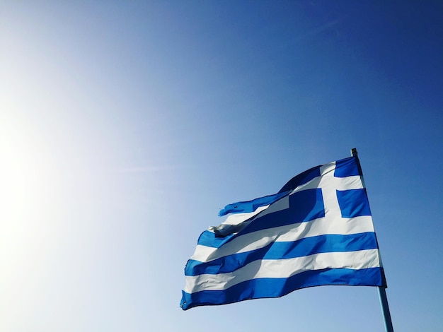 天空に対するギリシャ国旗の低角度の視点