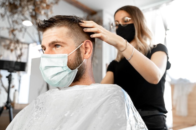 Inquadratura dal basso di un parrucchiere che si rade i capelli di un cliente