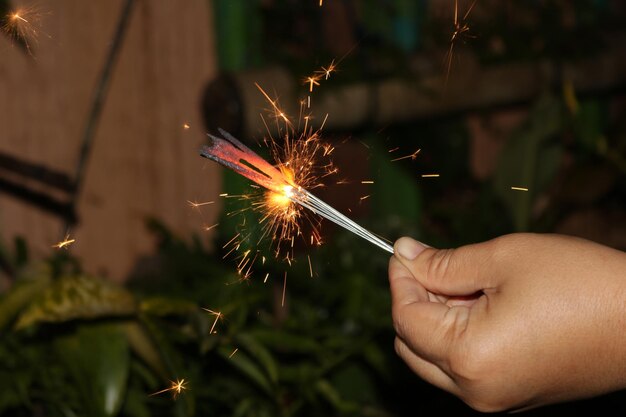 Photo low angle view of hand holding fireworks