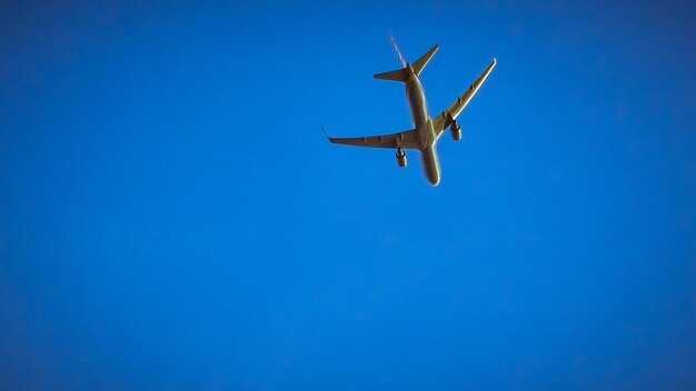 澄んだ青い空を背景に飛行するヘリコプターの低角度の視点