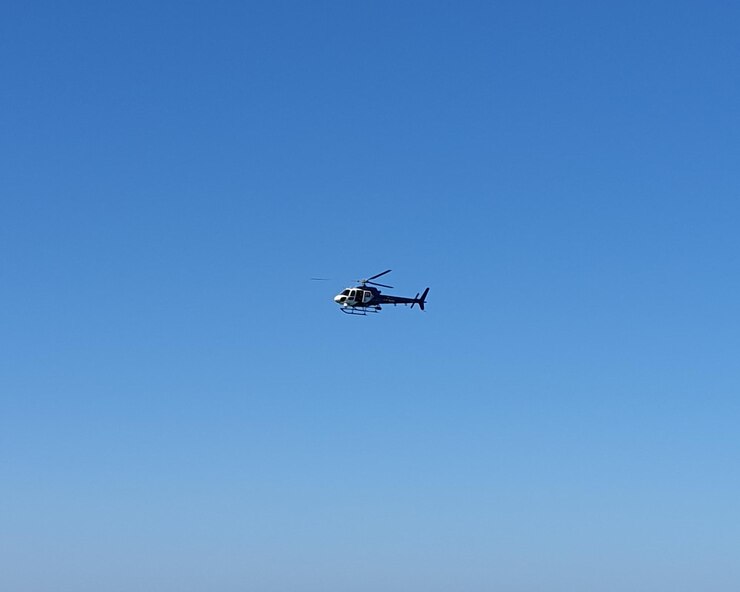Photo 澄んだ青い空を背景に飛行するヘリコプターの低角度の視点