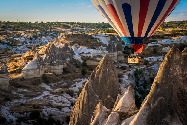 Photo low angle view of hot air balloon flying over mountains in cappadocia