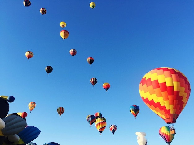 Low angle view of hot air balloons against blue sky