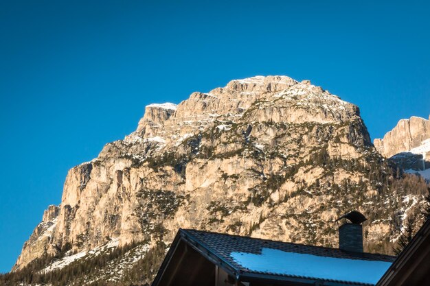 Low angle view of house and mountains against clear blue sky