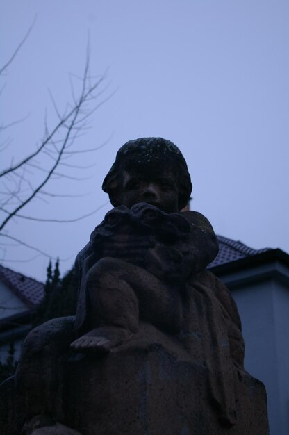 Photo low angle view of human sculpture against sky