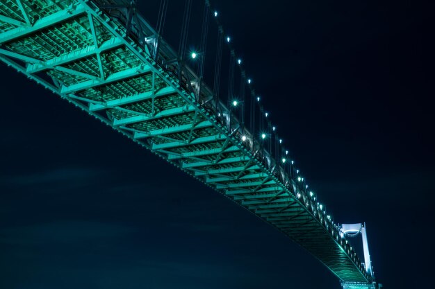 Photo low angle view of illuminated bridge against sky at night