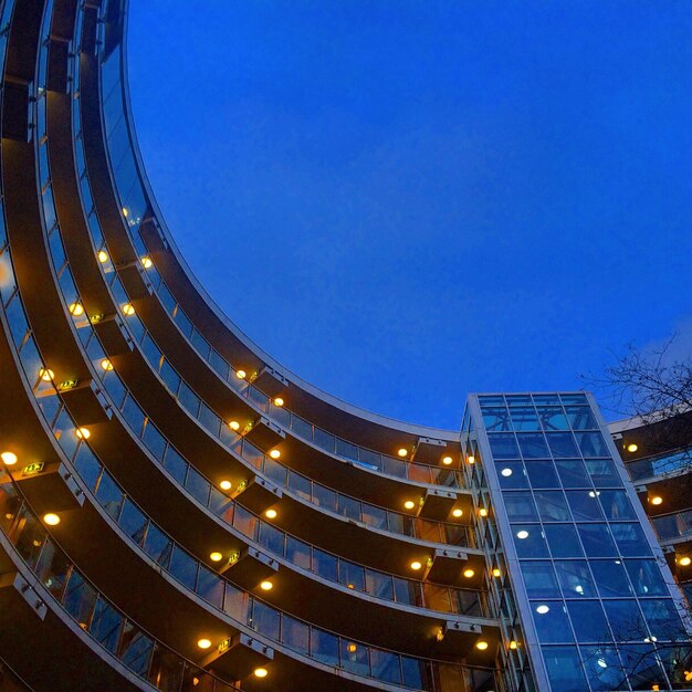 Foto vista a basso angolo di un edificio illuminato contro il cielo blu