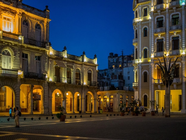 low angle view of illuminated buildings against clear sky at dusk