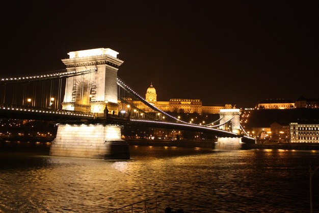 Photo low angle view of illuminated chain bridge over river against sky