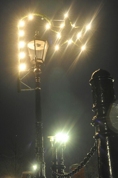 low angle view of illuminated christmas lights on street light against sky